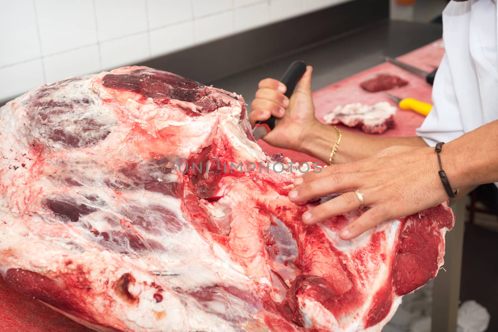 butcher cutting meat in the butchery. Close up