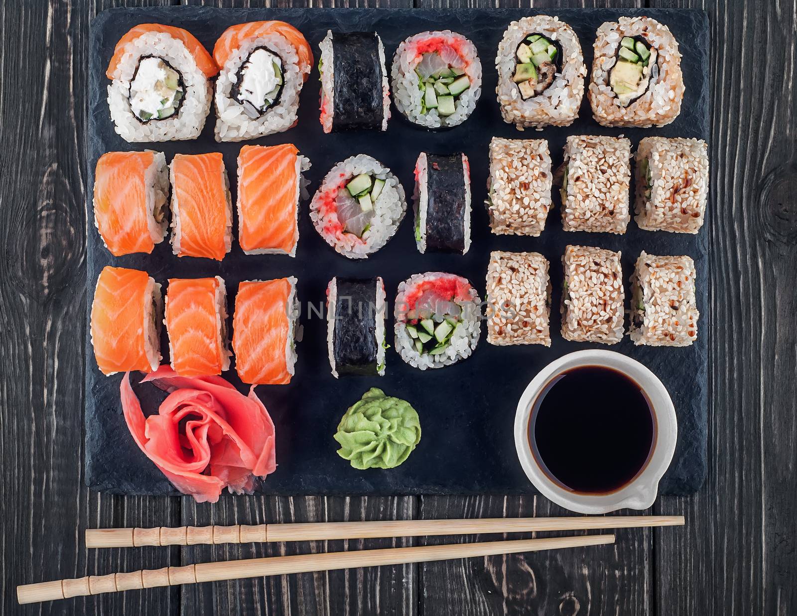 Various sushi rolls on slate by Cipariss