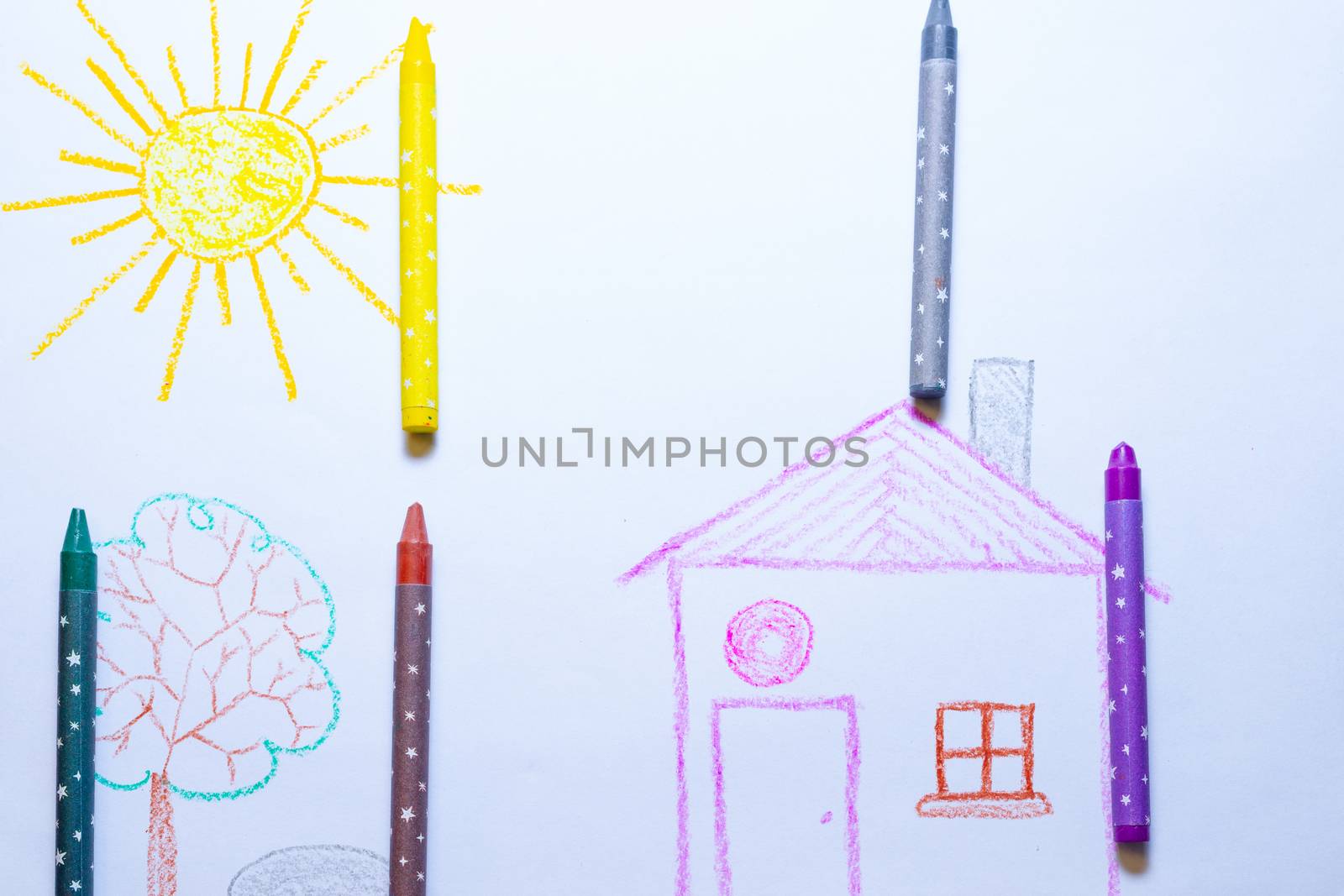 Children`s drawing of house, tree, sun and rock on white paper with wax pencils. Kindergarten age drawings.