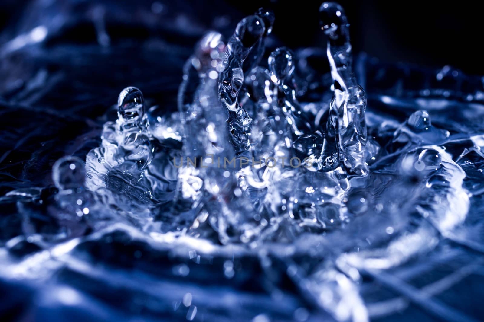 Water drops splashing on acoustic membrane. A lot of drops in air. High frequency of sound waves. Water cloud small drops. Frozen time shot.