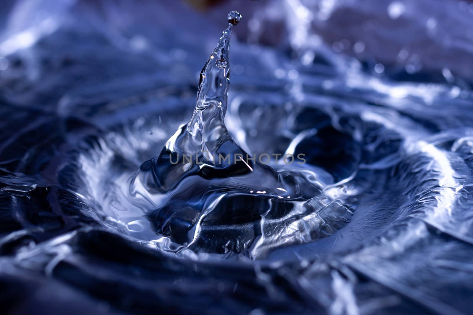 Water drops splashing on acoustic membrane. A lot of drops in air. High frequency of sound waves. Water cloud small drops. Frozen time shot.