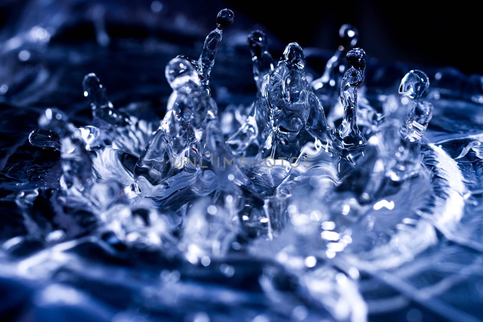 Water drops splashing on acoustic membrane. A lot of drops in air. High frequency of sound waves. Water cloud small drops. Frozen time shot.