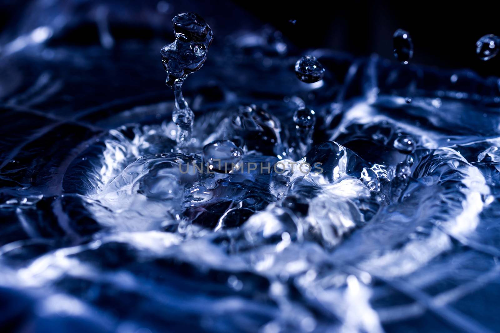 Water drops splashing on acoustic membrane. A lot of drops in air. High frequency of sound waves. Water cloud small drops. Frozen time shot.