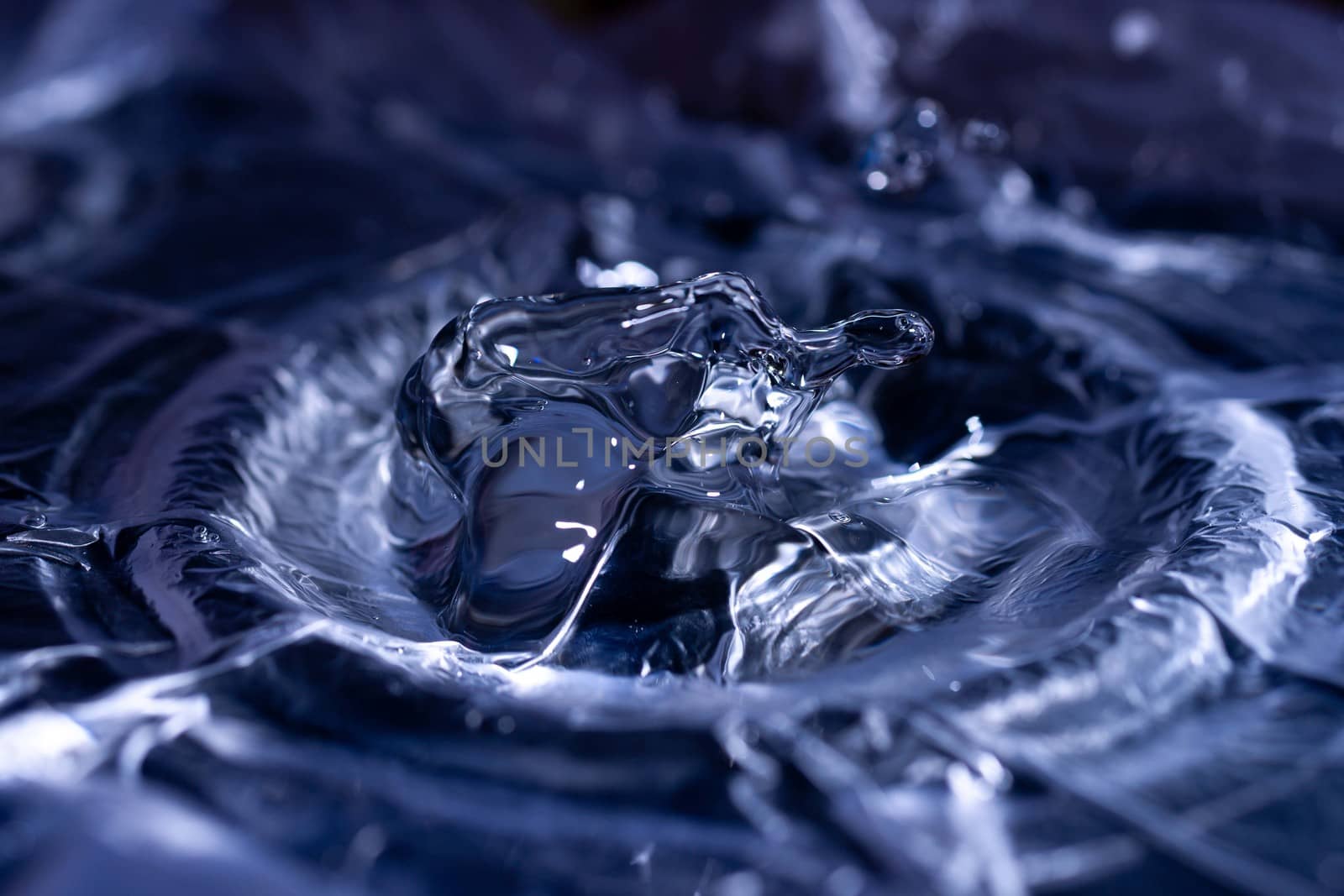 Water drops splashing on acoustic membrane. A lot of drops in air. High frequency of sound waves. Water cloud small drops. Frozen time shot.