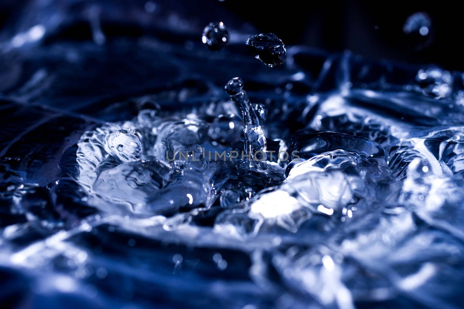 Water drops splashing on acoustic membrane. A lot of drops in air. High frequency of sound waves. Water cloud small drops. Frozen time shot.