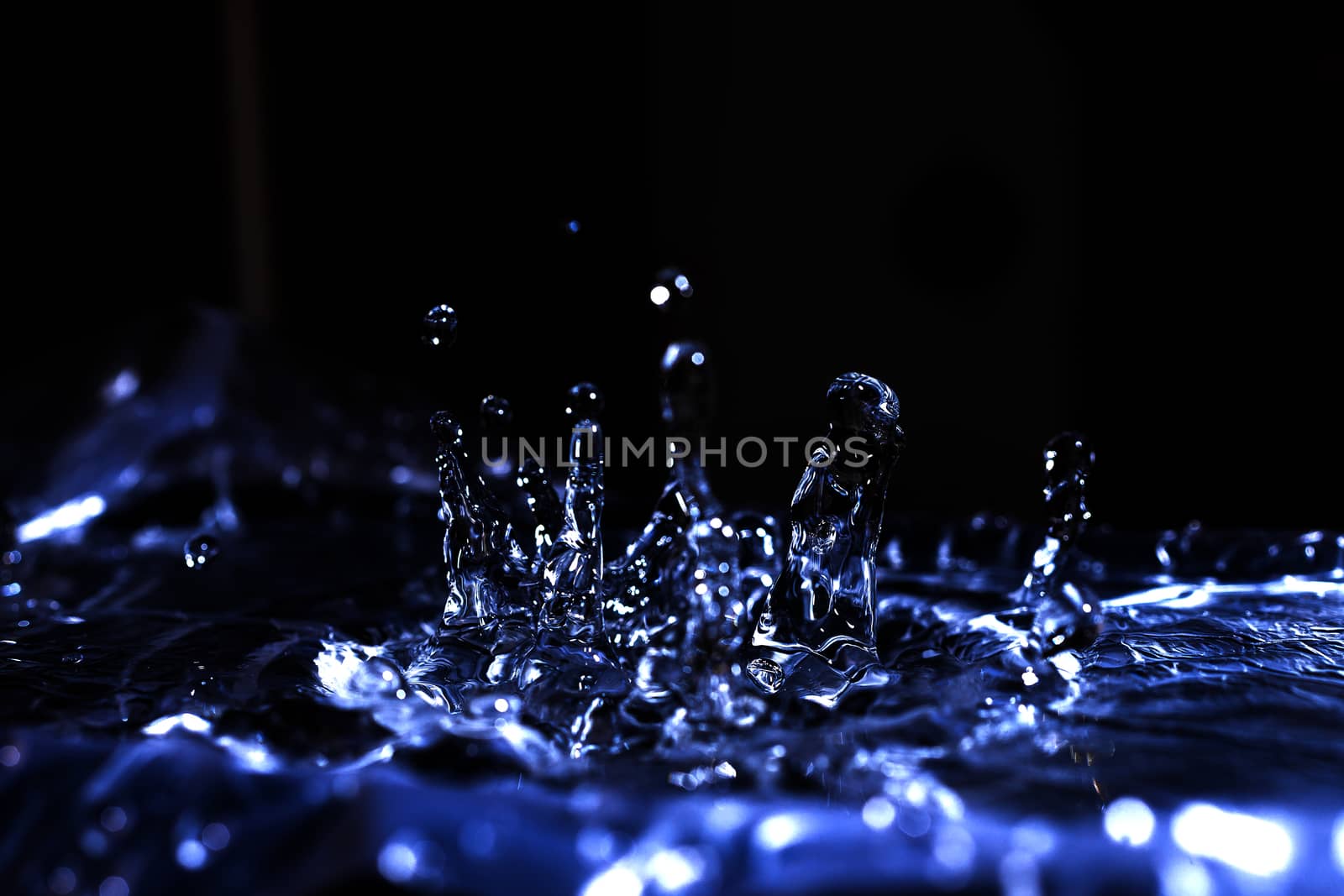 Water drops splashing on acoustic membrane. A lot of drops in air. High frequency of sound waves. Water cloud small drops. Frozen time shot.