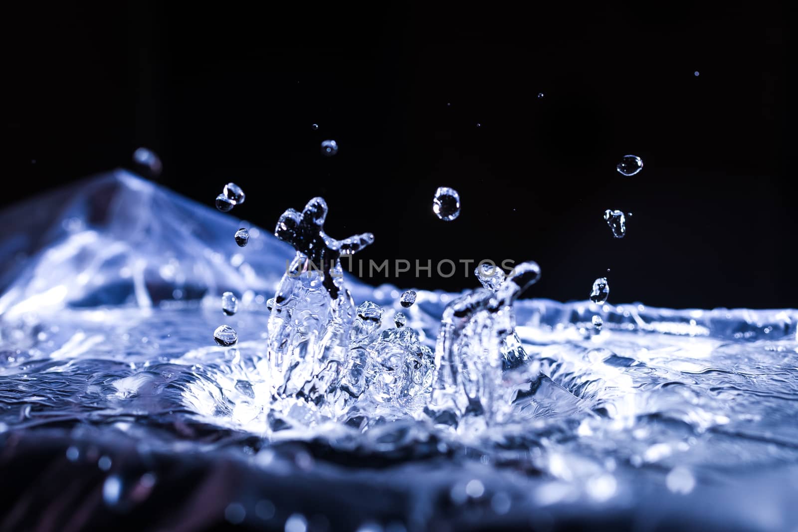 Water drops splashing on acoustic membrane. A lot of drops in air. High frequency of sound waves. Water cloud small drops. Frozen time shot. 