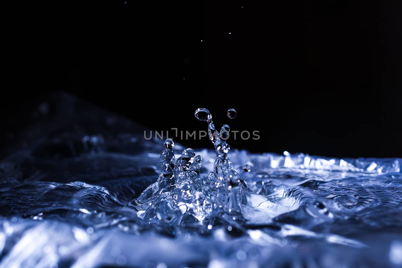 Water drops splashing on acoustic membrane. A lot of drops in air. High frequency of sound waves. Water cloud small drops. Frozen time shot. 