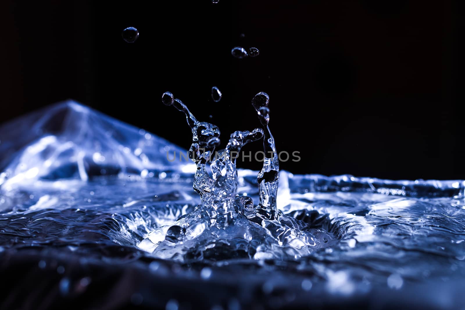 Water drops splashing on acoustic membrane. A lot of drops in air. High frequency of sound waves. Water cloud small drops. Frozen time shot. 