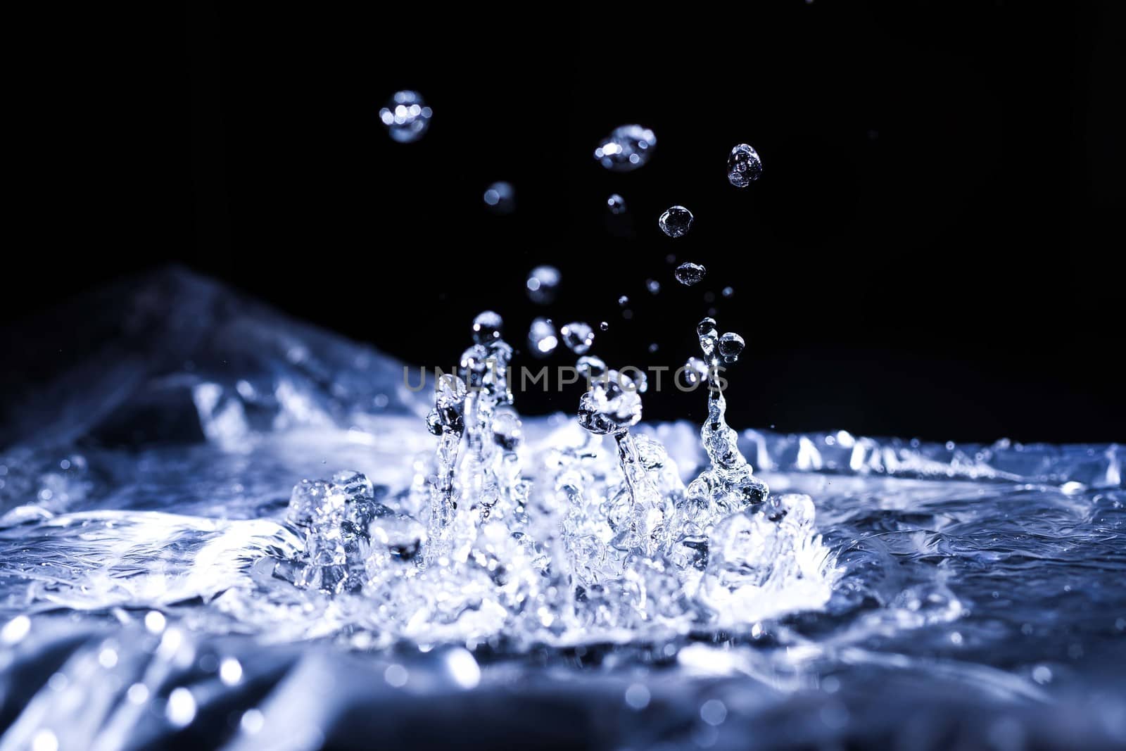 Water drops splashing on acoustic membrane. A lot of drops in air. High frequency of sound waves. Water cloud small drops. Frozen time shot. 