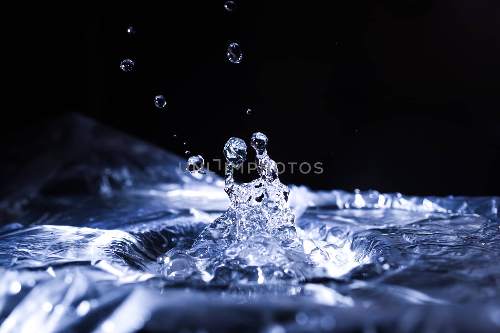 Water drops splashing on acoustic membrane. A lot of drops in air. High frequency of sound waves. Water cloud small drops. Frozen time shot. 