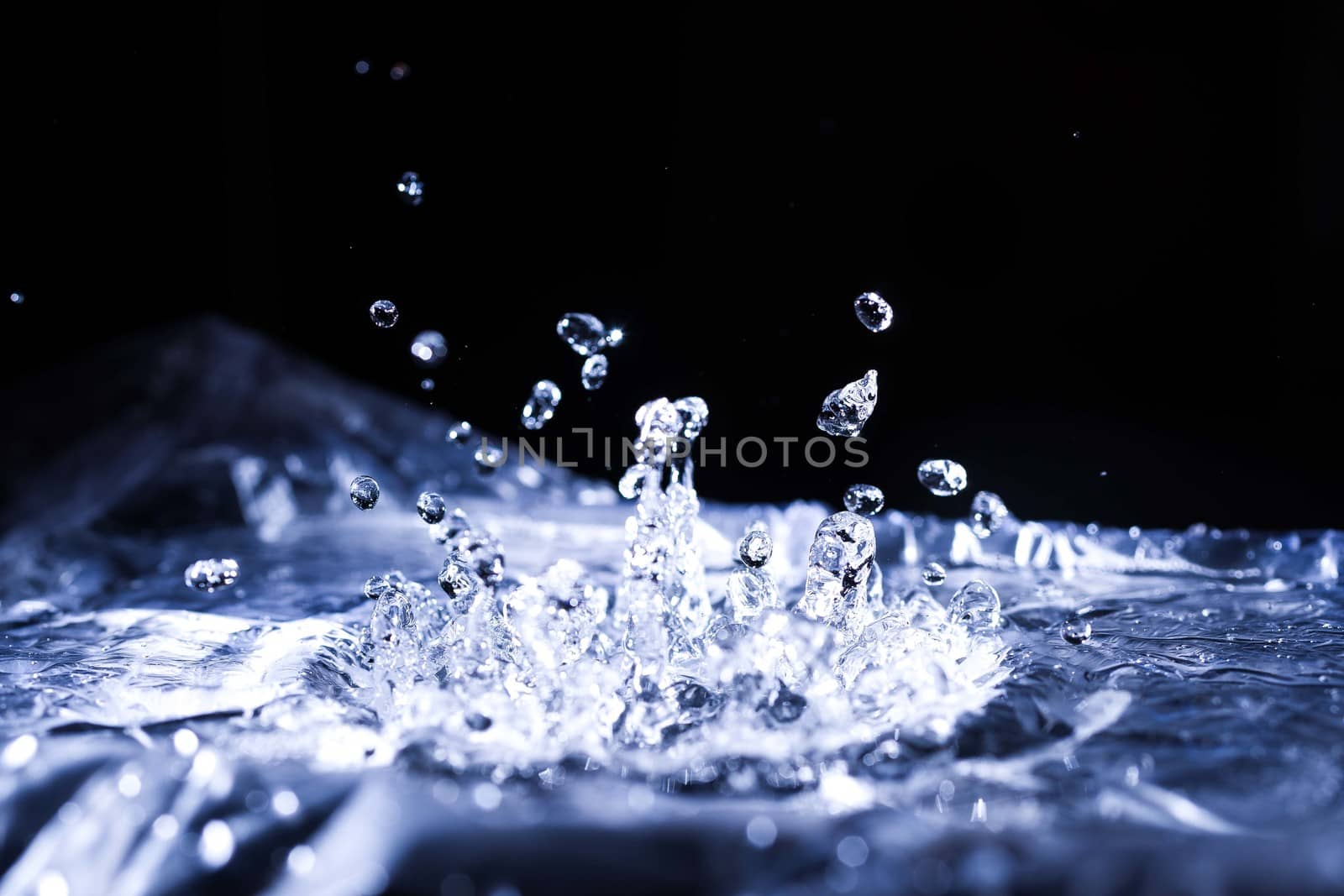 Water drops splashing on acoustic membrane. A lot of drops in air. High frequency of sound waves. Water cloud small drops. Frozen time shot. 