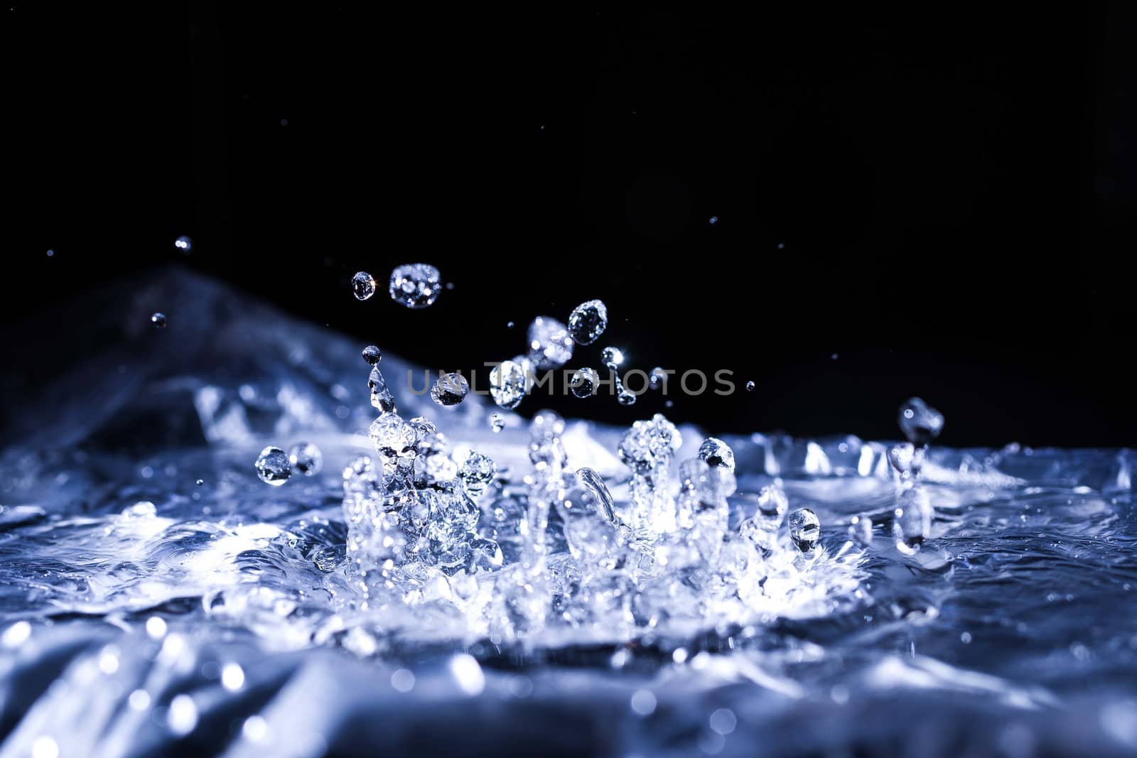 Water drops splashing on acoustic membrane. A lot of drops in air. High frequency of sound waves. Water cloud small drops. Frozen time shot.