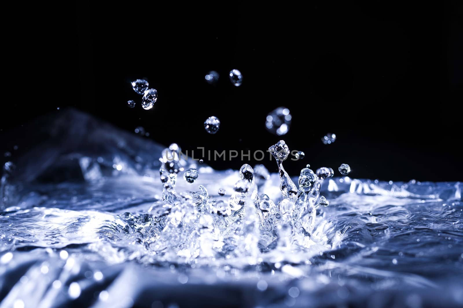 Water drops splashing on acoustic membrane. A lot of drops in air. High frequency of sound waves. Water cloud small drops. Frozen time shot. 