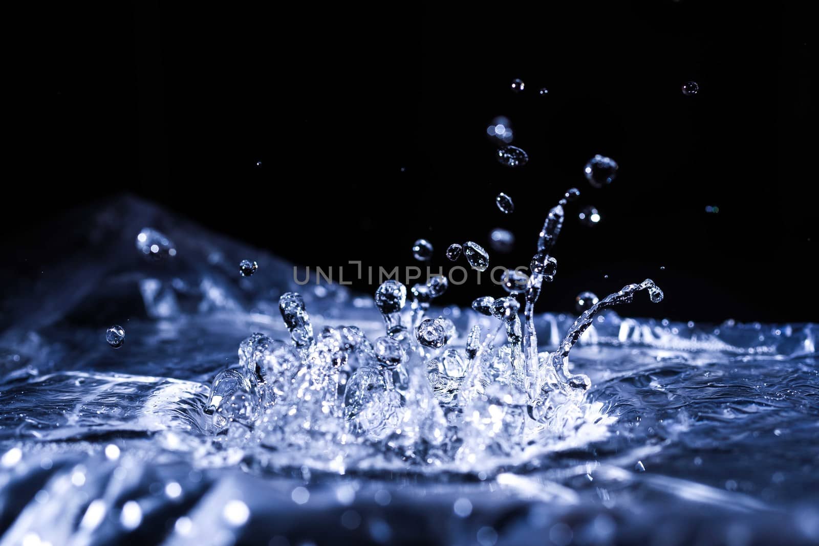 Water drops splashing on acoustic membrane. A lot of drops in air. High frequency of sound waves. Water cloud small drops. Frozen time shot. 