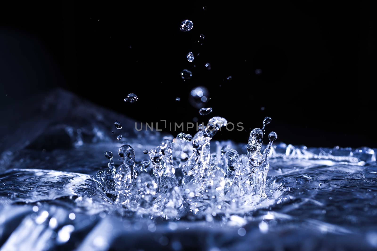 Water drops splashing on acoustic membrane. A lot of drops in air. High frequency of sound waves. Water cloud small drops. Frozen time shot. 
