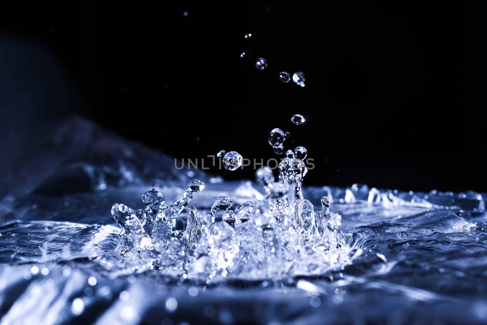 Water drops splashing on acoustic membrane. A lot of drops in air. High frequency of sound waves. Water cloud small drops. Frozen time shot. 