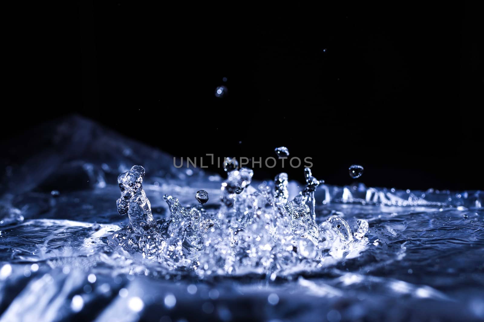 Water drops splashing on acoustic membrane. A lot of drops in air. High frequency of sound waves. Water cloud small drops. Frozen time shot. 