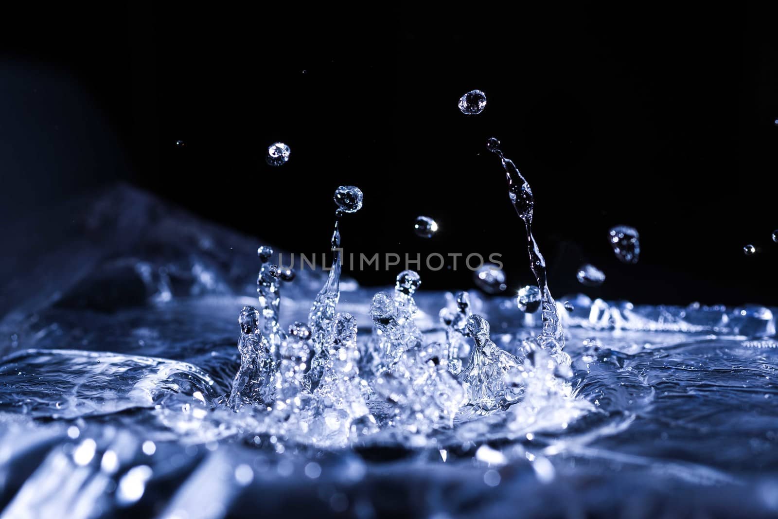 Water drops splashing on acoustic membrane. A lot of drops in air. High frequency of sound waves. Water cloud small drops. Frozen time shot. 