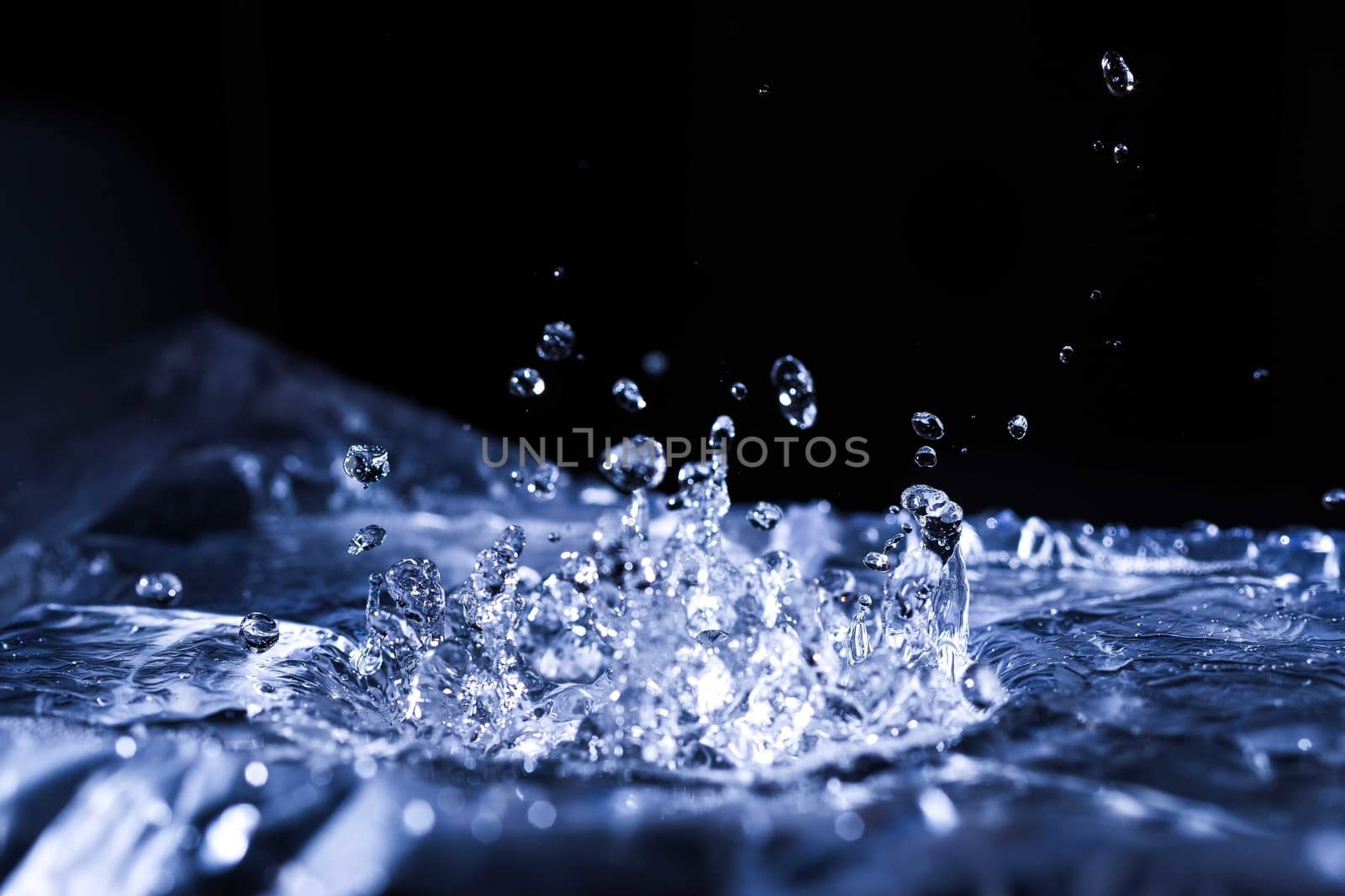 Water drops splashing on acoustic membrane. A lot of drops in air. High frequency of sound waves. Water cloud small drops. Frozen time shot. 