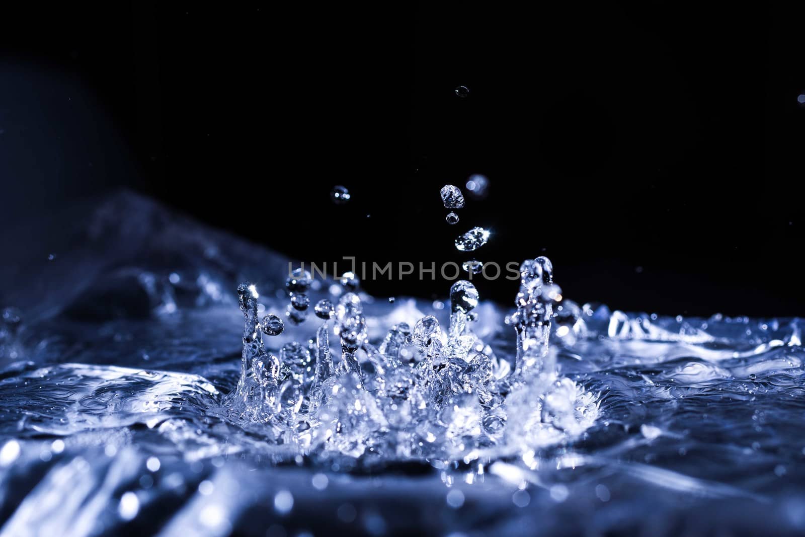 Water drops splashing on acoustic membrane. A lot of drops in air. High frequency of sound waves. Water cloud small drops. Frozen time shot. 