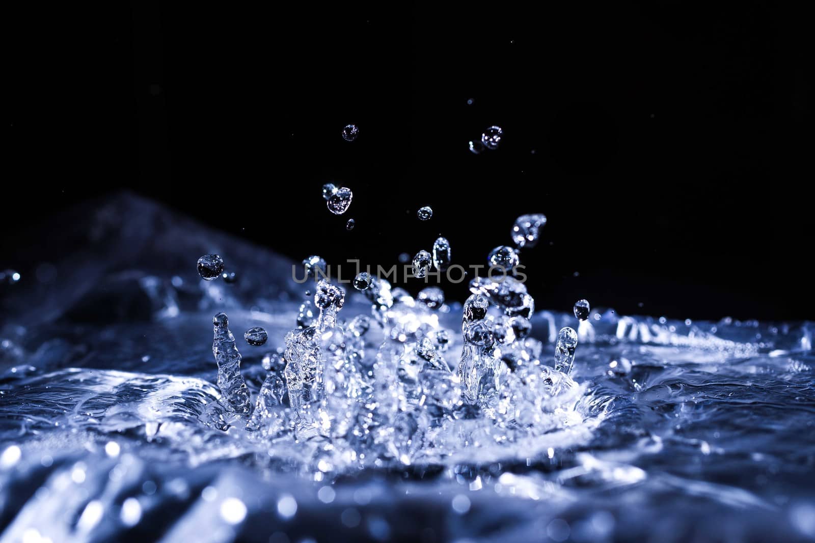 Water drops splashing on acoustic membrane. A lot of drops in air. High frequency of sound waves. Water cloud small drops. Frozen time shot. 