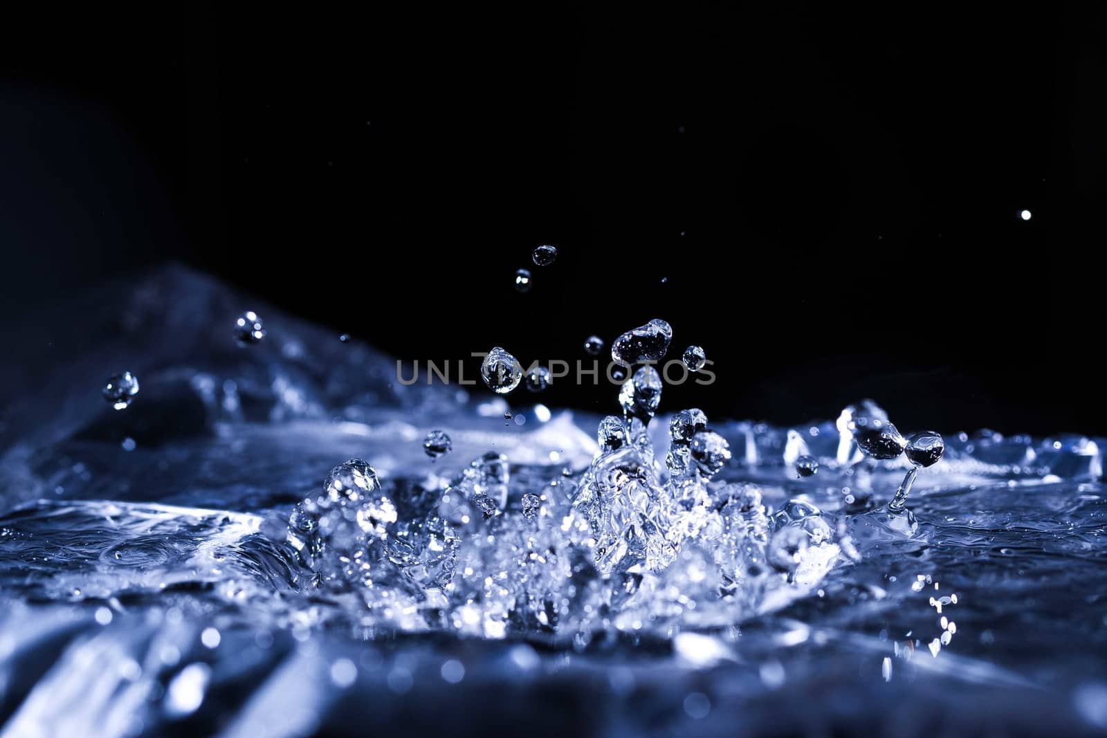Water drops splashing on acoustic membrane. A lot of drops in air. High frequency of sound waves. Water cloud small drops. Frozen time shot. 