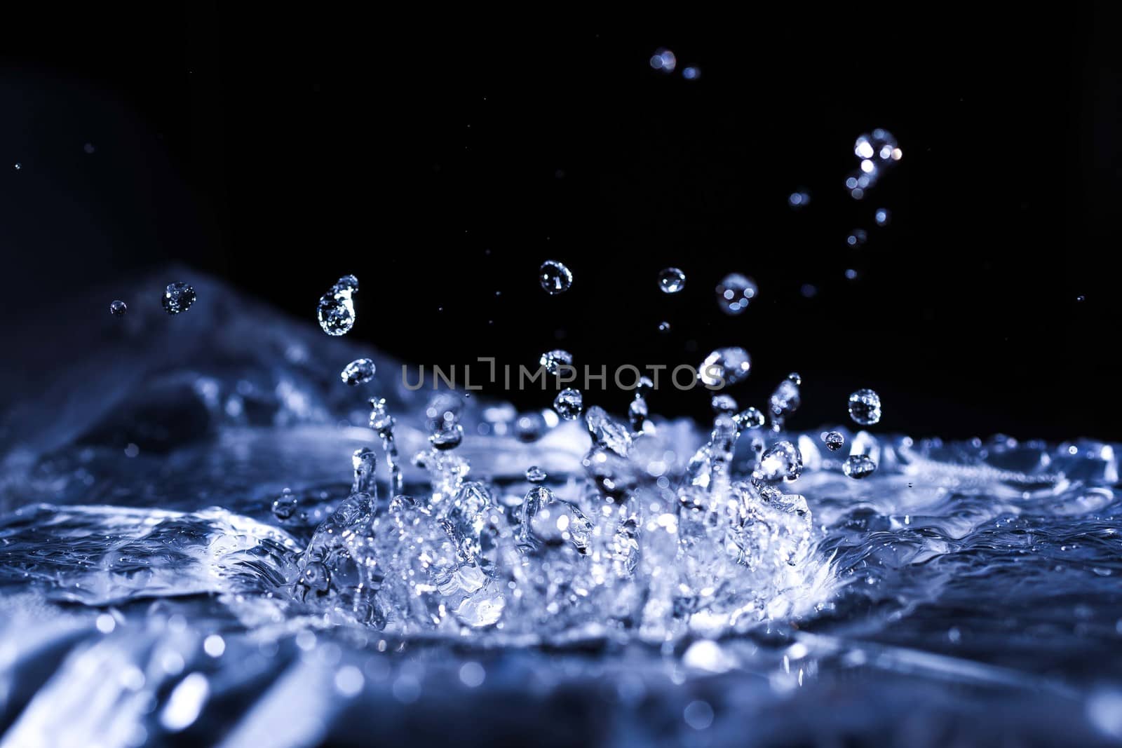 Water drops splashing on acoustic membrane. A lot of drops in air. High frequency of sound waves. Water cloud small drops. Frozen time shot. 