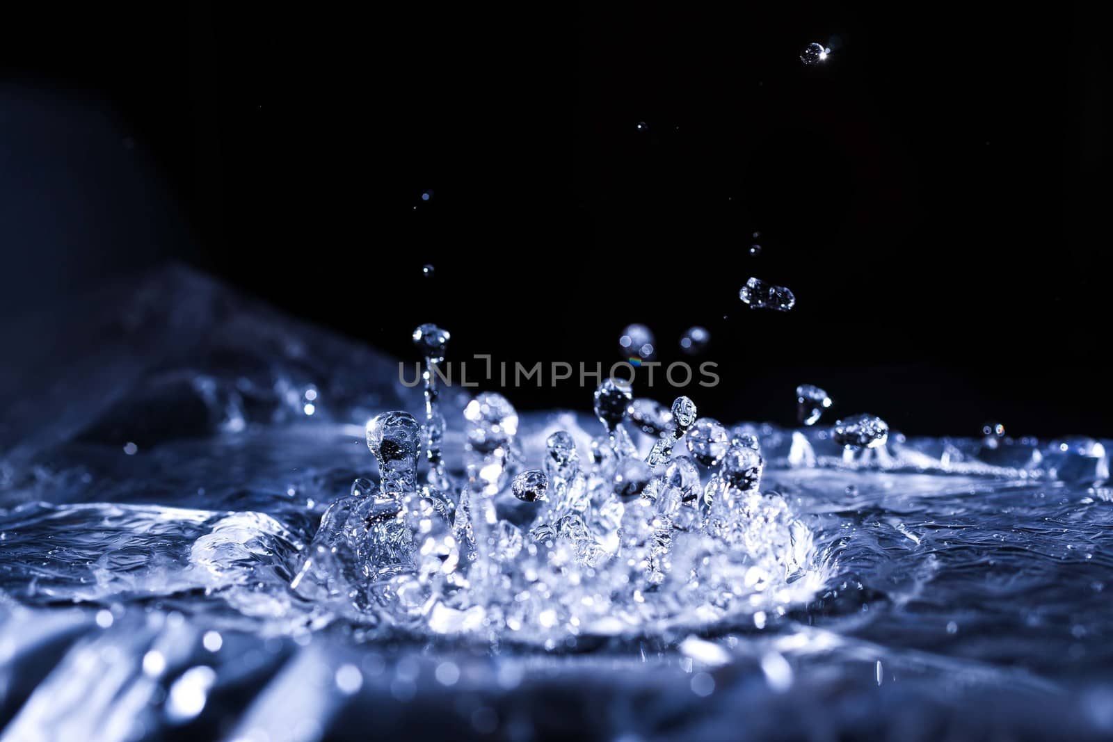 Water drops splashing on acoustic membrane. A lot of drops in air. High frequency of sound waves. Water cloud small drops. Frozen time shot. 