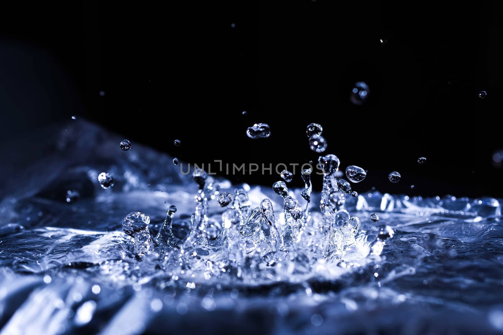Water drops splashing on acoustic membrane. A lot of drops in air. High frequency of sound waves. Water cloud small drops. Frozen time shot. 