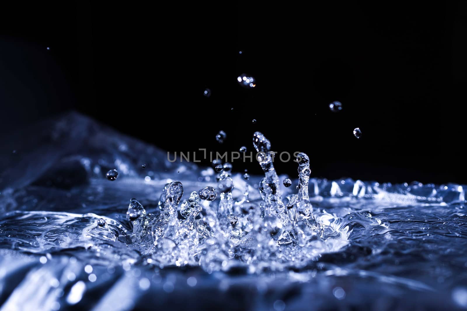 Water drops splashing on acoustic membrane. A lot of drops in air. High frequency of sound waves. Water cloud small drops. Frozen time shot.