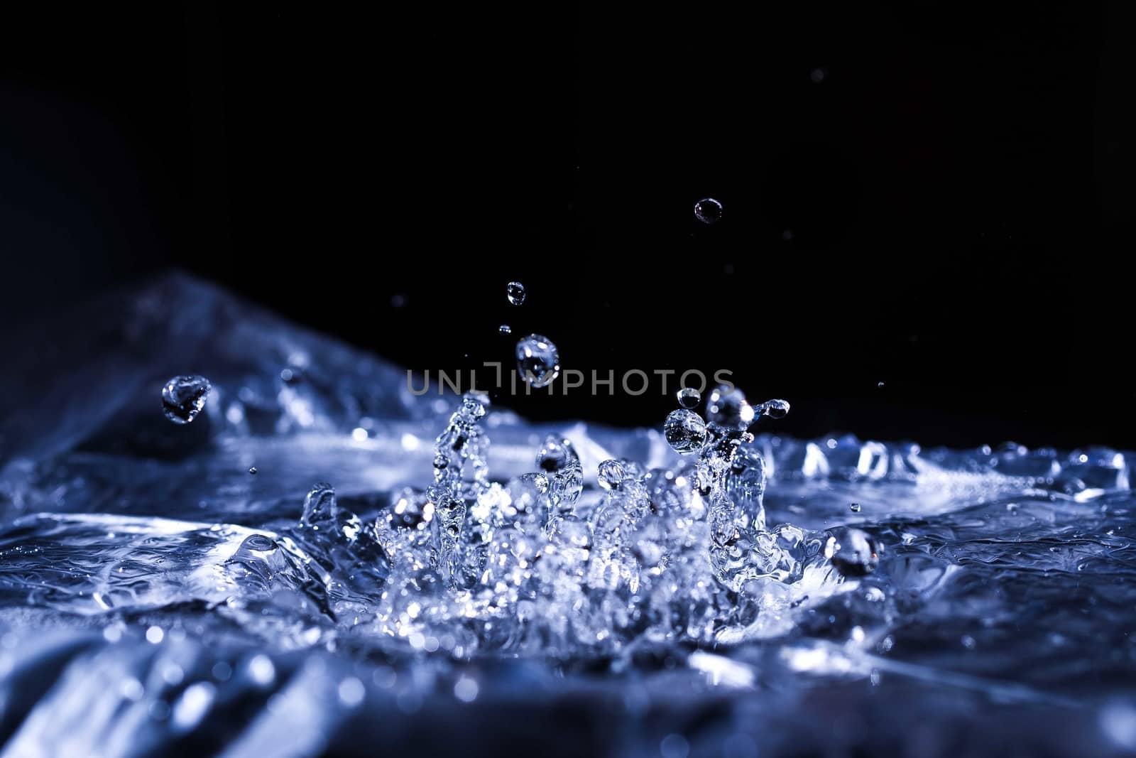 Water drops splashing on acoustic membrane. A lot of drops in air. High frequency of sound waves. Water cloud small drops. Frozen time shot. 