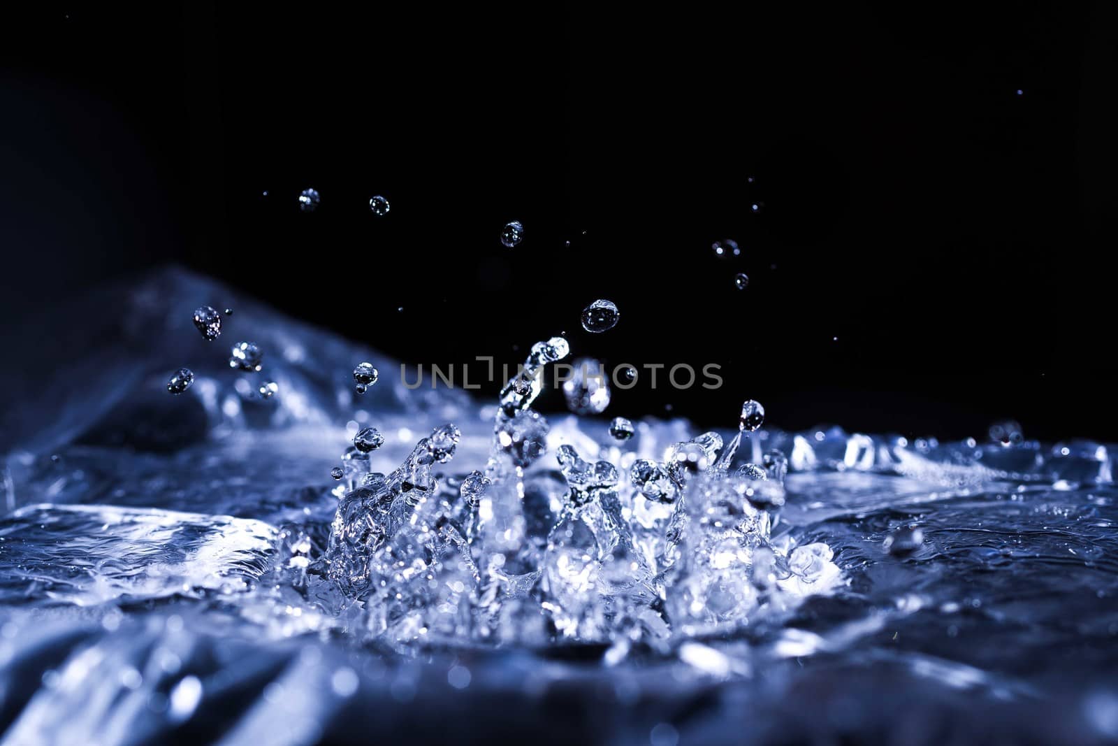 Water drops splashing on acoustic membrane. A lot of drops in air. High frequency of sound waves. Water cloud small drops. Frozen time shot. 