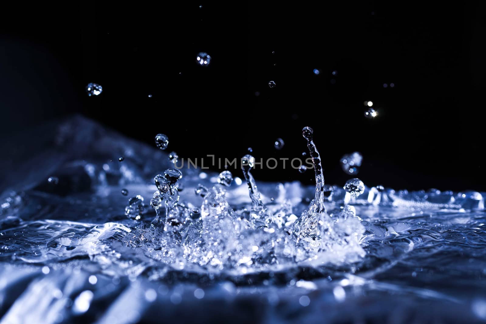 Water drops splashing on acoustic membrane. A lot of drops in air. High frequency of sound waves. Water cloud small drops. Frozen time shot. 