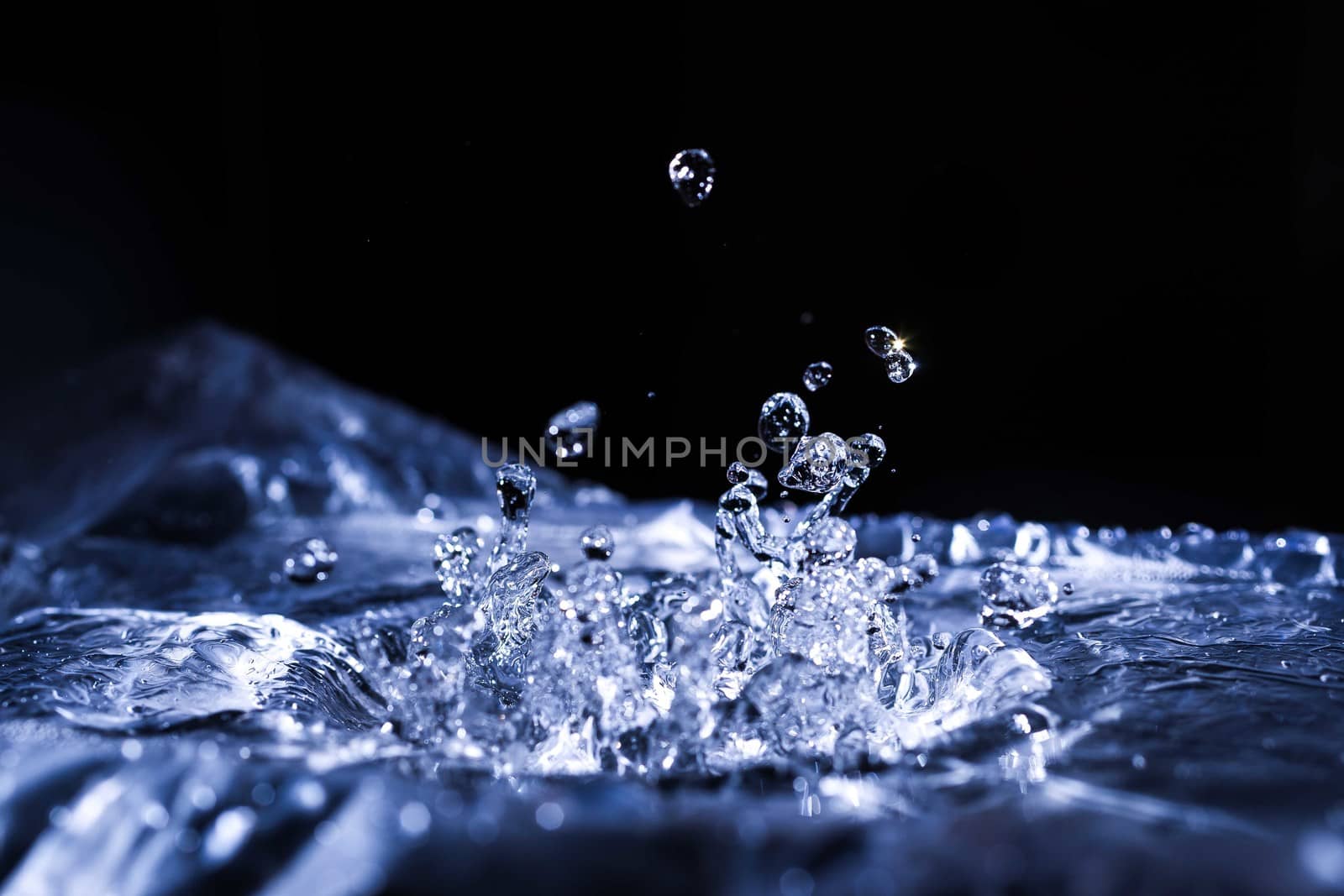 Water drops splashing on acoustic membrane. A lot of drops in air. High frequency of sound waves. Water cloud small drops. Frozen time shot.