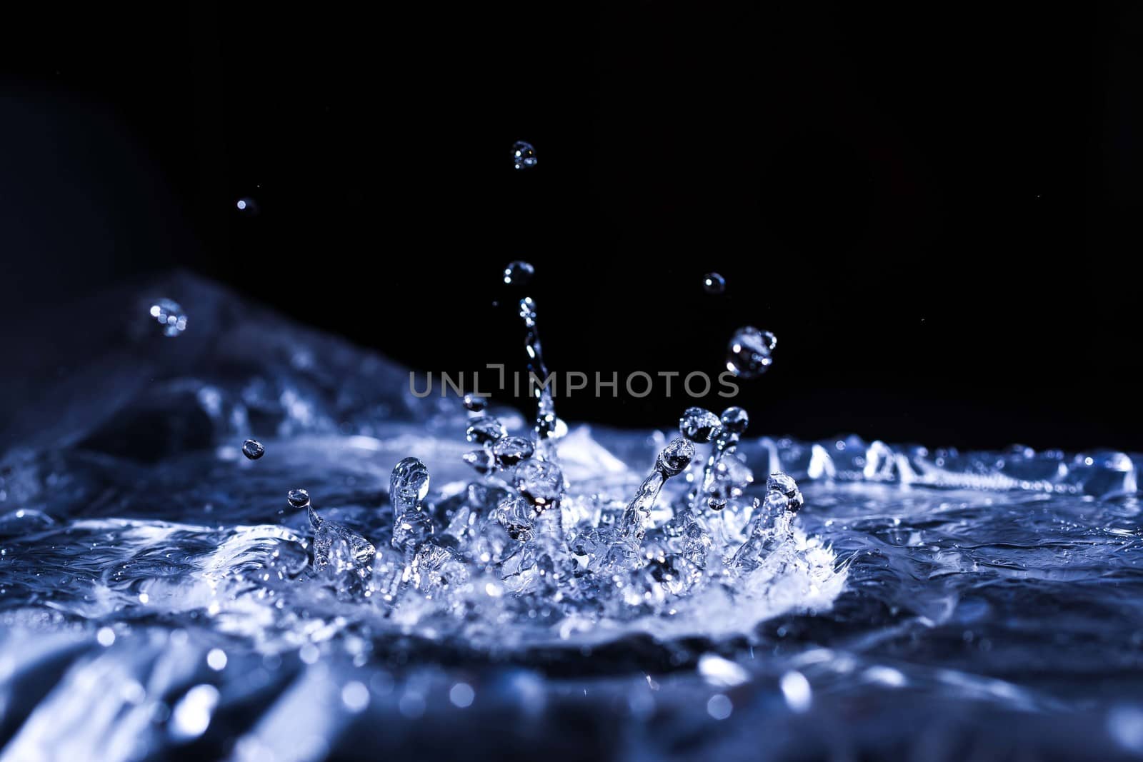Water drops splashing on acoustic membrane. A lot of drops in air. High frequency of sound waves. Water cloud small drops. Frozen time shot.