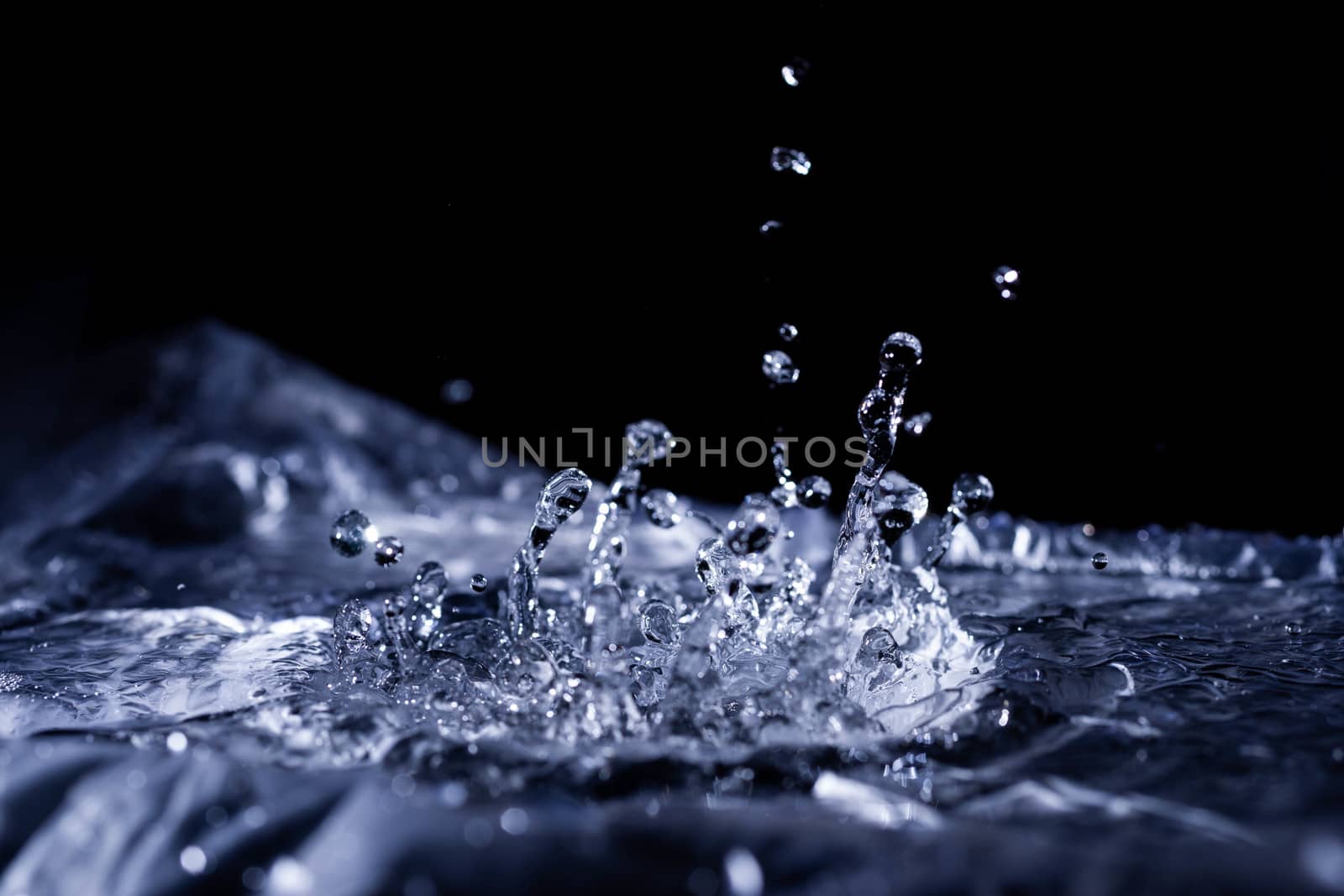 Water drops splashing on acoustic membrane. A lot of drops in air. High frequency of sound waves. Water cloud small drops. Frozen time shot. 