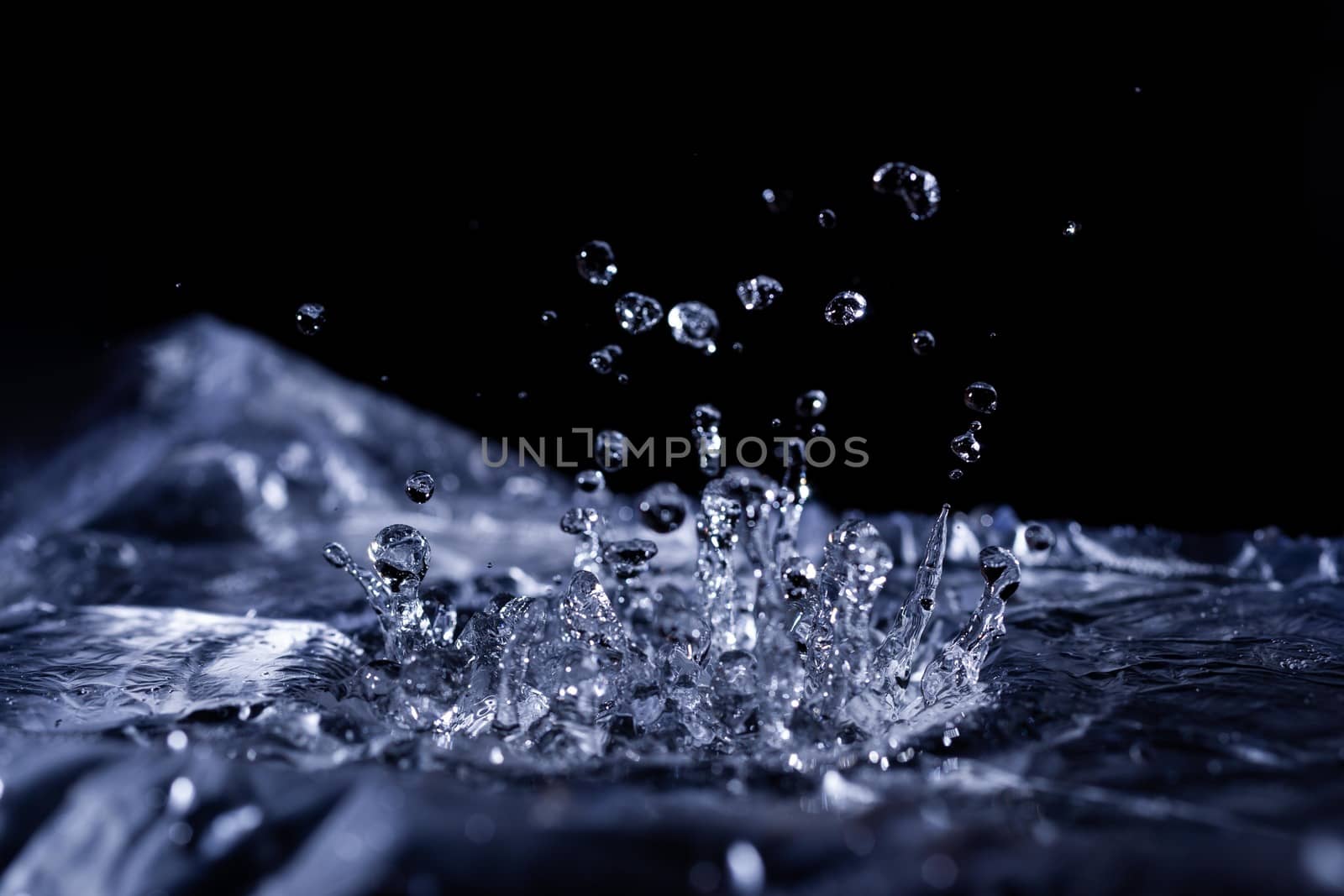 Water drops splashing on acoustic membrane. A lot of drops in air. High frequency of sound waves. Water cloud small drops. Frozen time shot. 