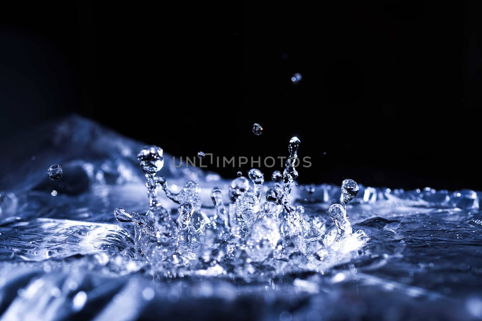 Water drops splashing on acoustic membrane. A lot of drops in air. High frequency of sound waves. Water cloud small drops. Frozen time shot.