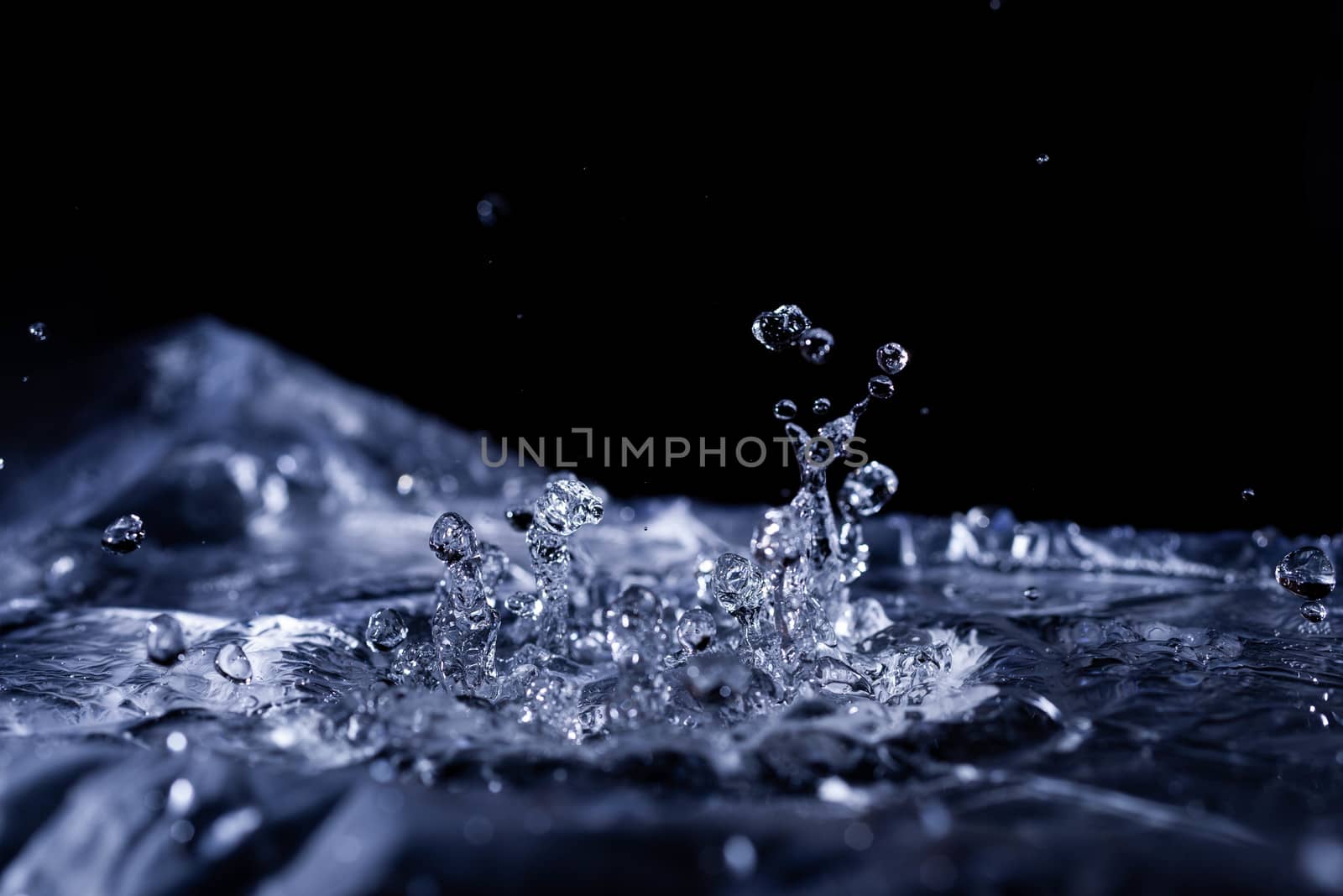 Water drops splashing on acoustic membrane. A lot of drops in air. High frequency of sound waves. Water cloud small drops. Frozen time shot. 
