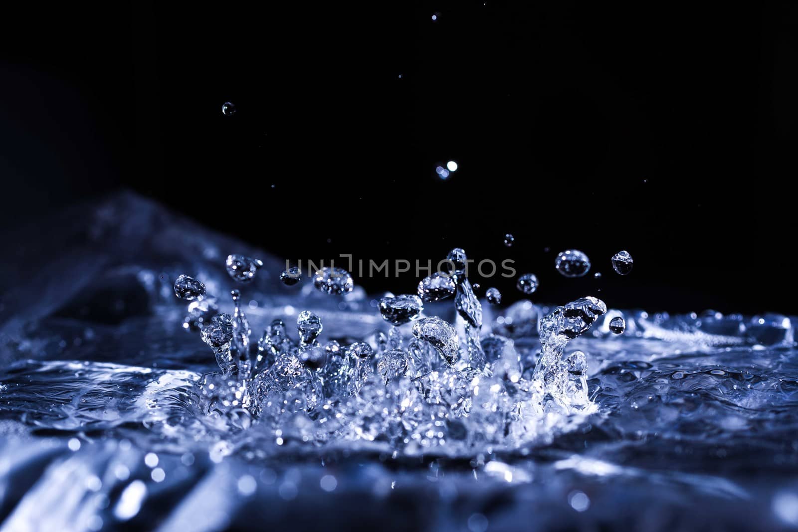 Water drops splashing on acoustic membrane. A lot of drops in air. High frequency of sound waves. Water cloud small drops. Frozen time shot. 