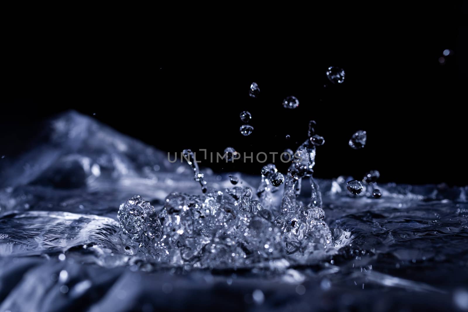 Water drops splashing on acoustic membrane. A lot of drops in air. High frequency of sound waves. Water cloud small drops. Frozen time shot. 