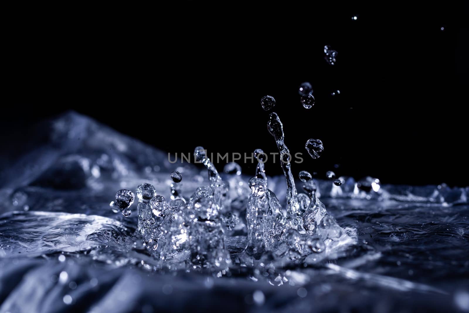 Water drops splashing on acoustic membrane. A lot of drops in air. High frequency of sound waves. Water cloud small drops. Frozen time shot. 