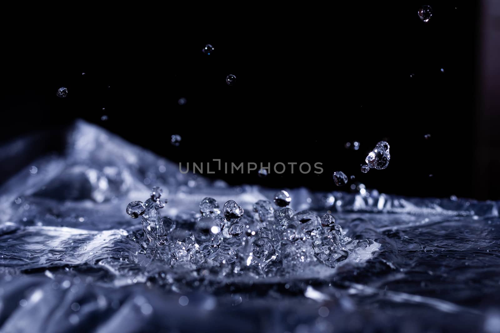 Water drops splashing on acoustic membrane. A lot of drops in air. High frequency of sound waves. Water cloud small drops. Frozen time shot. 