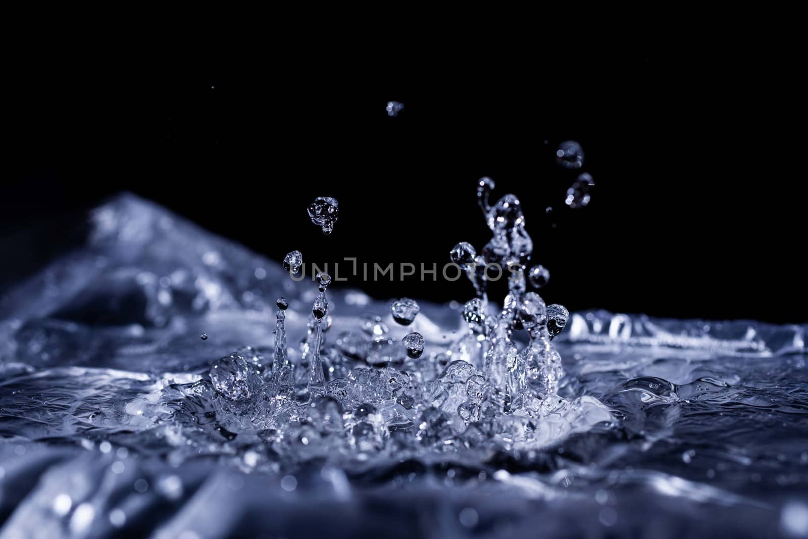 Water drops splashing on acoustic membrane. A lot of drops in air. High frequency of sound waves. Water cloud small drops. Frozen time shot. 