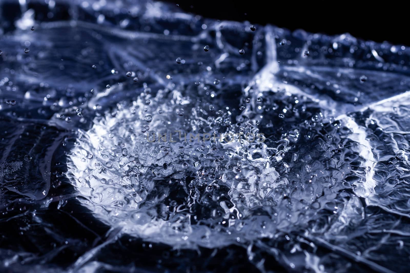 Water drops splashing on acoustic membrane. A lot of drops in air. High frequency of sound waves. Water cloud small drops. Frozen time shot.