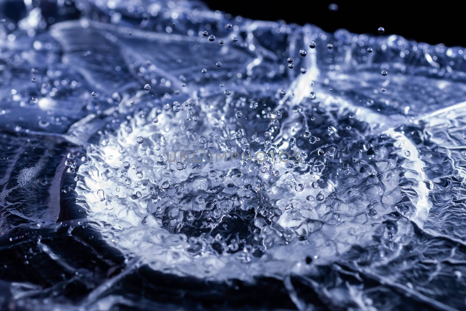 Water drops splashing on acoustic membrane. A lot of drops in air. High frequency of sound waves. Water cloud small drops. Frozen time shot.