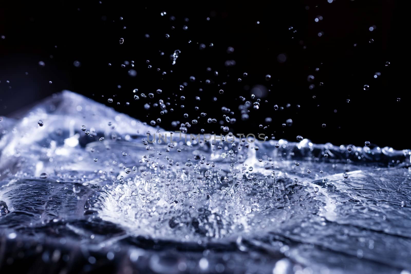 Water drops splashing on acoustic membrane. A lot of drops in air. High frequency of sound waves. Water cloud small drops. Frozen time shot.
