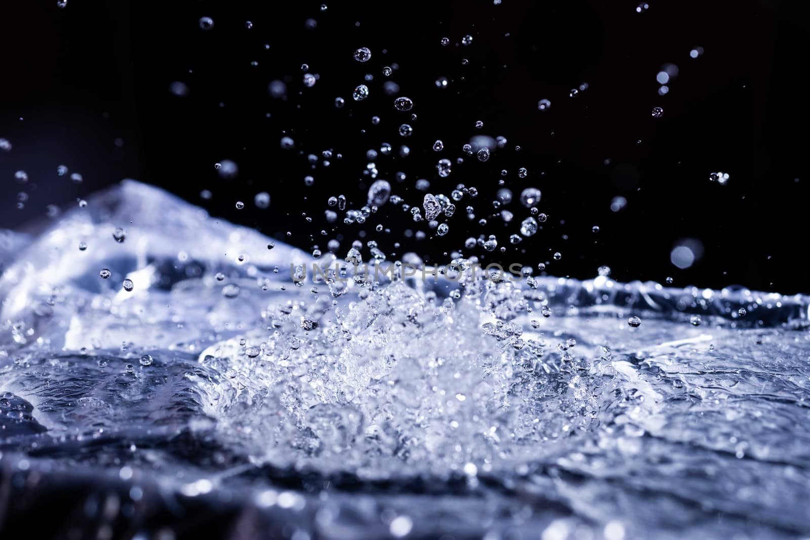 Water drops splashing on acoustic membrane. A lot of drops in air. High frequency of sound waves. Water cloud small drops. Frozen time shot.