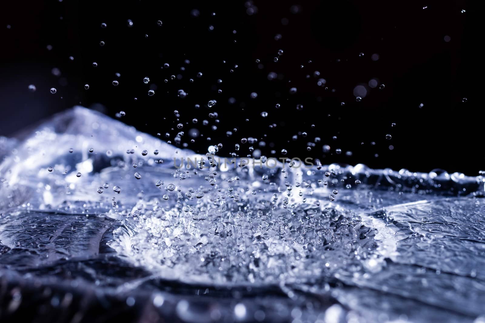 Water drops splashing on acoustic membrane. A lot of drops in air. High frequency of sound waves. Water cloud small drops. Frozen time shot.